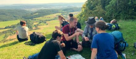 Eine Gruppe junger Aktiver sitzt auf der Gobert Höhe am Grünen Band und plant den weiteren Weg.