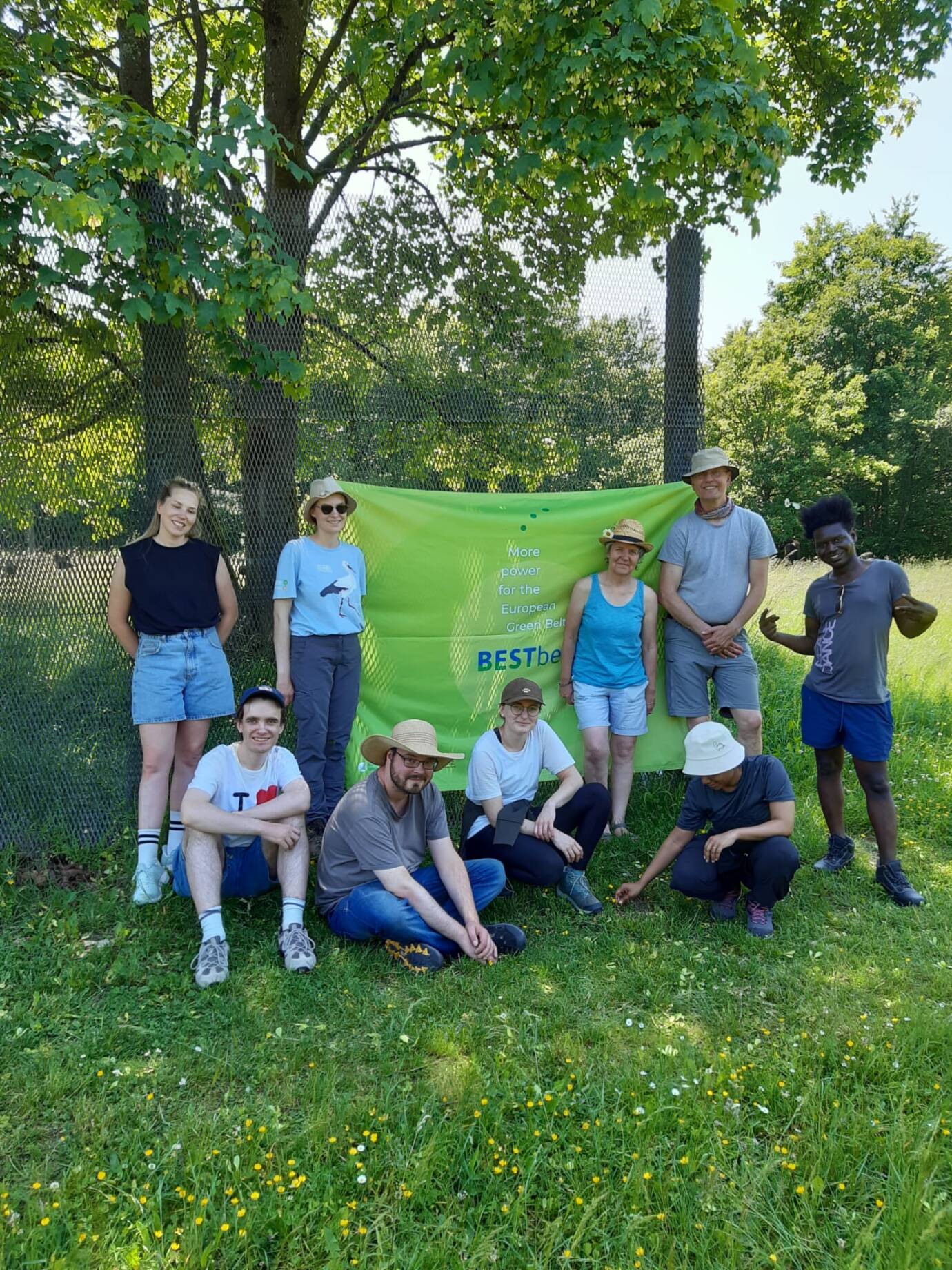 Gruppe mit Banner draußen im Grünen