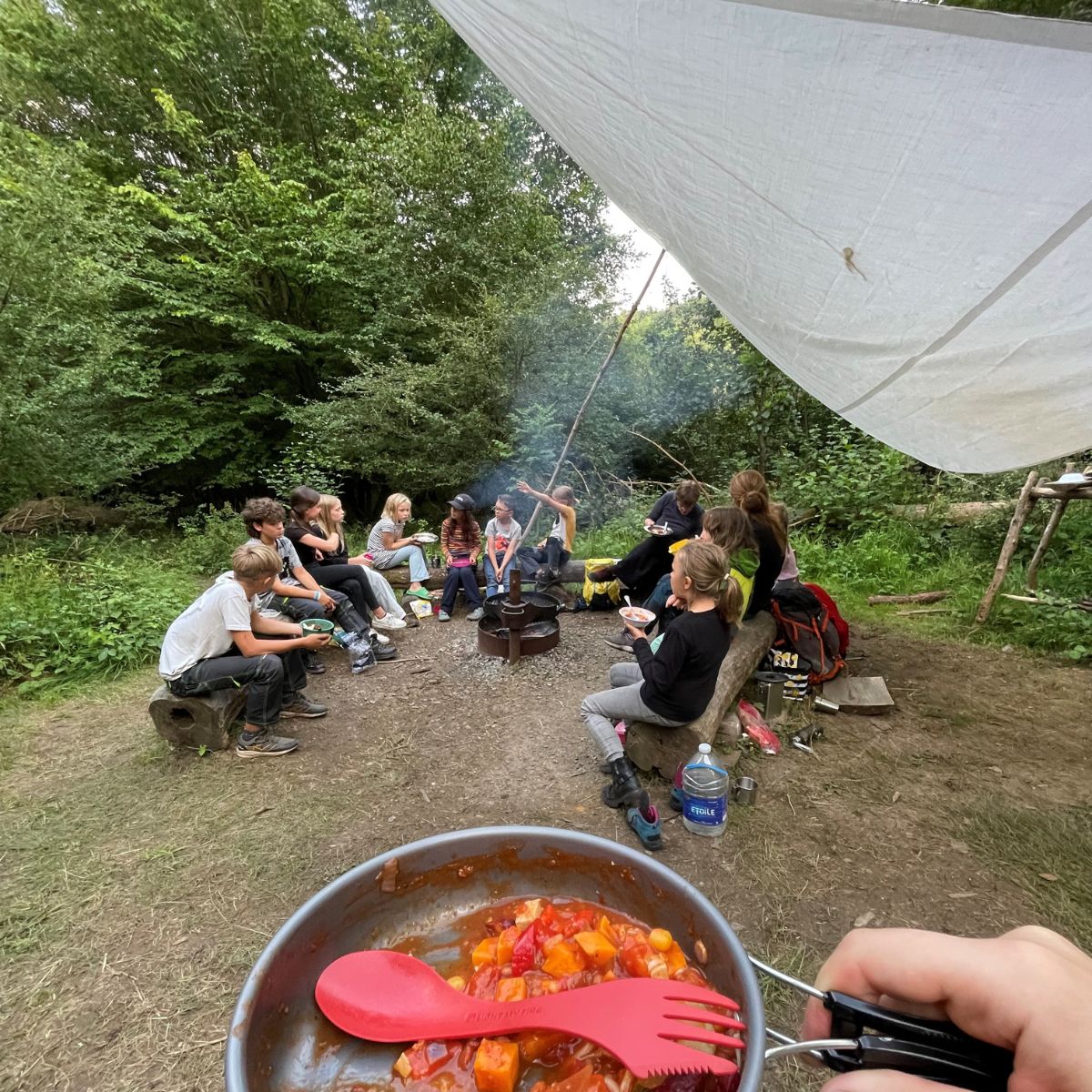 Kindergruppe beim Camping mit Essen in der Natur